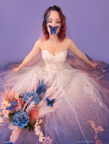 artist in pink and purple wedding dress with blue butterflies and a bouquet