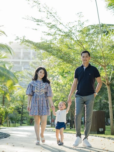 oung family enjoying a peaceful walk through the tropical gardens at The Apurva Kempinski Bali