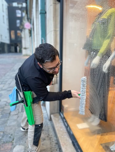 Technicien de M & M Services Pro nettoyant la vitrine du magasin Léo et Ugo à Rouen