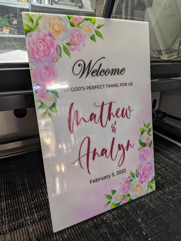 Acrylic wedding sign with floral design and text.