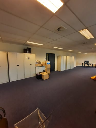 Espace vide avant transformation en bureaux avec une porte et des armoires.