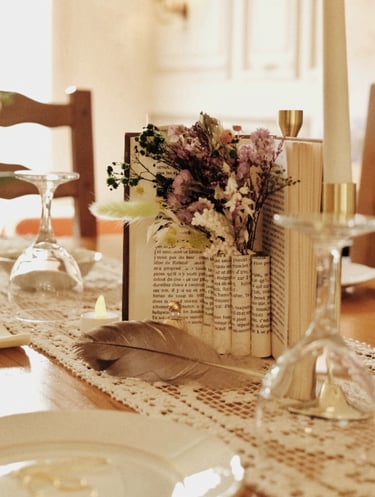 Centre de table avec livre, fleurs séchées et napperons