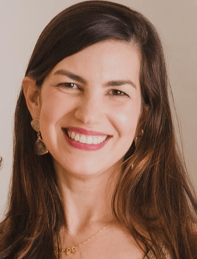 a woman with long hair and a gold necklace