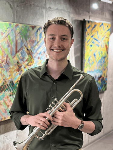 Ben Van Wienen in a green shirt holding his trumpet