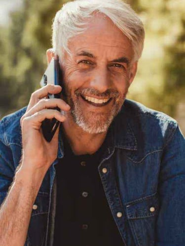 Ein Mann mit Bart und handy, der lächelt