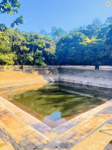 Amrita Sarovar, a symmetrical stepped pond at Nandi Hills, surrounded by stone steps and greenery