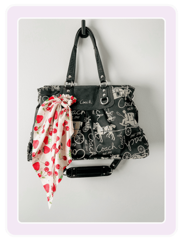 Black Coach tote bag with horse and carriage print and a strawberry pattern silk scarf.