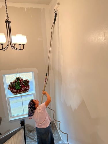 Team member painting stairway wall.