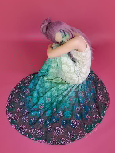Wedding Dress with a teal green dip dye and 3-d painted pink flowers around the hem on a model