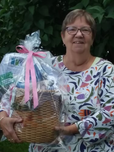 Photo of a smiling woman holding a gift basket used to raffle and raise money for the club