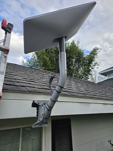 A Starlink satellite internet dish mounted on a residential roof using a wall pivot mount.