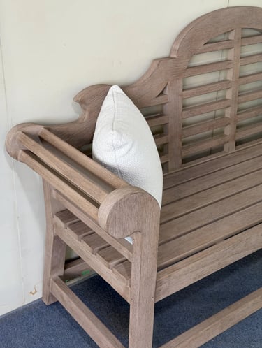Wooden garden bench with white cushion, showing a simple and comfortable seat for a peaceful garden 