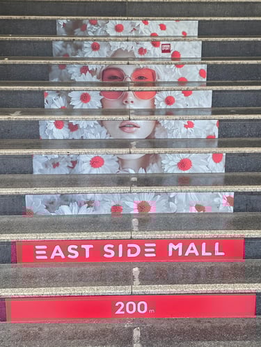 a large poster of a woman's face on a staircase case