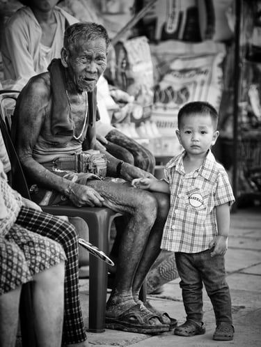 Old Thai man and his grandson - by Peter Pickering
