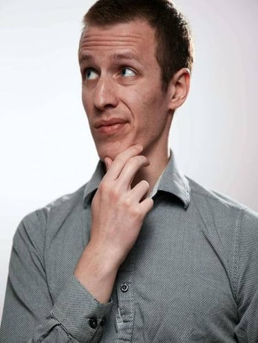 Man thinking thoughtfully, representing questions or reflection.