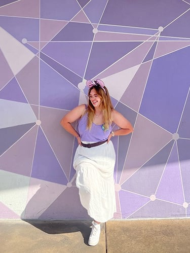 Ameliah Knopp pictured in front of the Purple Wall at Disney's Magic Kingdom® Park.