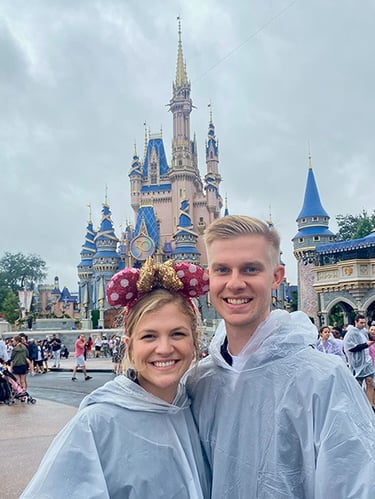 Kasey Kalk pictured with her husband in front of Cinderella Castle at Disney's Magic Kingdom®.