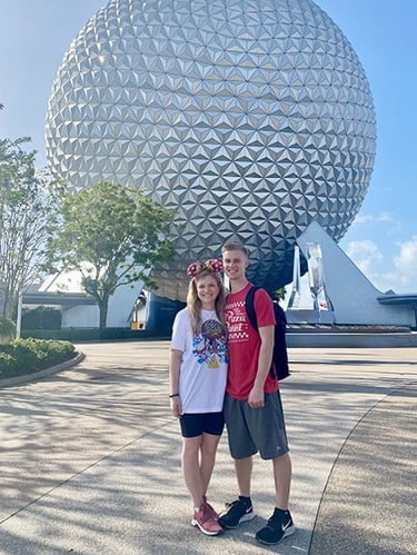Kasey Kalk pictured with her husband in front of Spaceship Earth at EPCOT®.