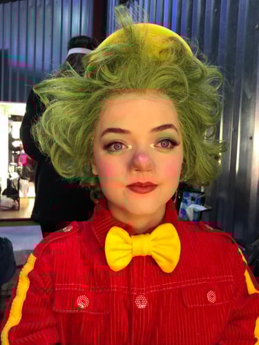 A character from a production displaying theatrical makeup  