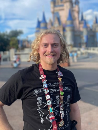 Minnie's Travel Boutique travel advisor Zach Stout pictured in front of Cinderella Castle at Disney's Magic Kingdom® Park.