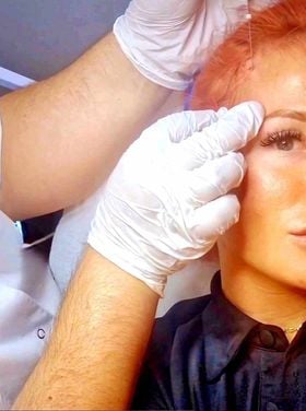 a woman with red hair and gloves on