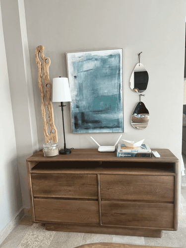 Rincón decorativo con inspiración marina, libros de surf y espejo en forma de gota | KARÄNA