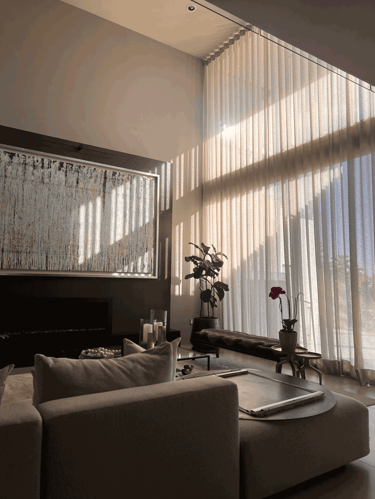 Sala iluminada naturalmente con ventanales altos y mobiliario elegante | KARÄNA