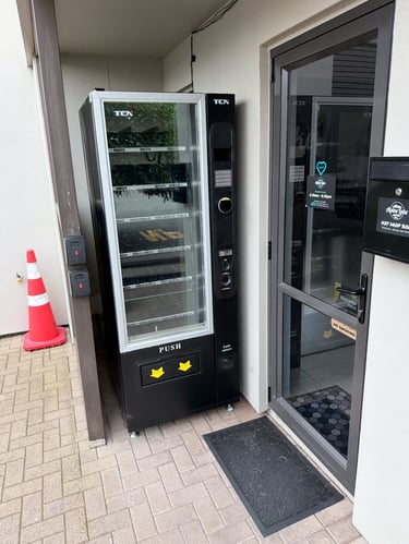 Commercial refrigerated vending machine stocked with snacks and beverages in Australia.