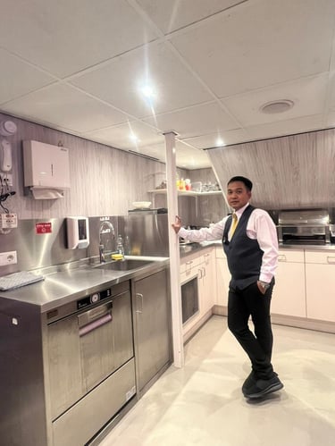 River crew standing in a modern stainless steel galley kitchen.