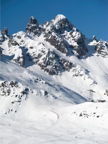Dramatic close-up of rugged snow-covered mountain peaks under a clear winter sky.