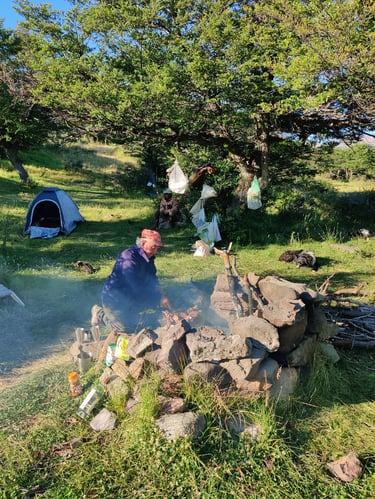 People are gathered around a campfire at a campsite.