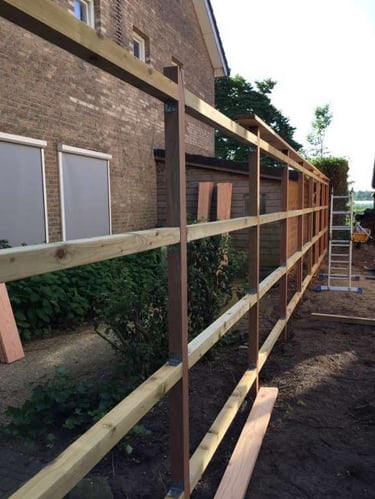 Structure en bois pour clôture de jardin en construction – montage des traverses avant fixation des