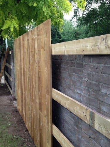 Pose de clôture en bois avec lames verticales sur structure en bois – assemblage en cours sur terrai