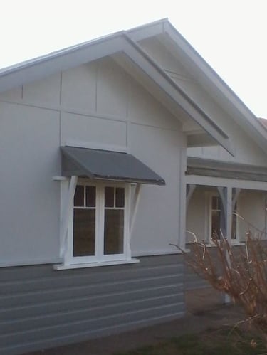 Exterior house repaint detail showing painted weatherboard finish