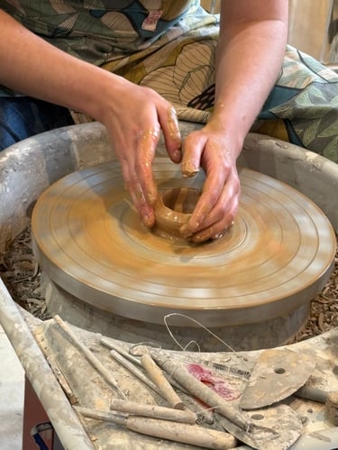 Photo de mains d'une artisane en train de travailler une céramique