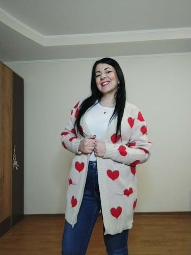 Woman wearing apricot heart print long cardigan sweater with pockets, ribbed knit open front