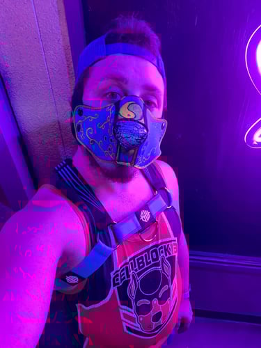 Man in a half-pup mask in a club.