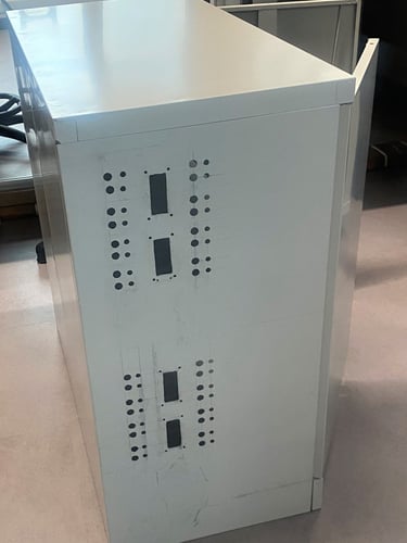 Holes made into a steel cabinet for electrical bulkhead connections