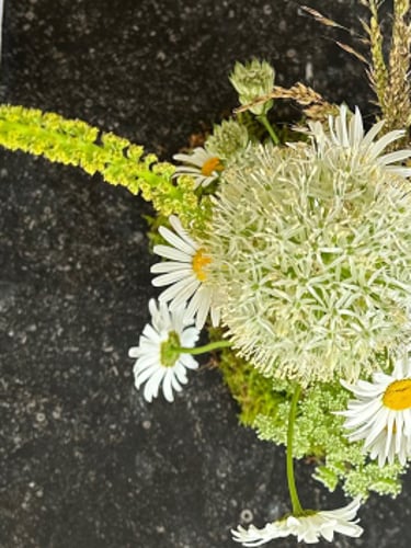 vue du dessus d'une. composition de table avec des anthemis et des album blanc 