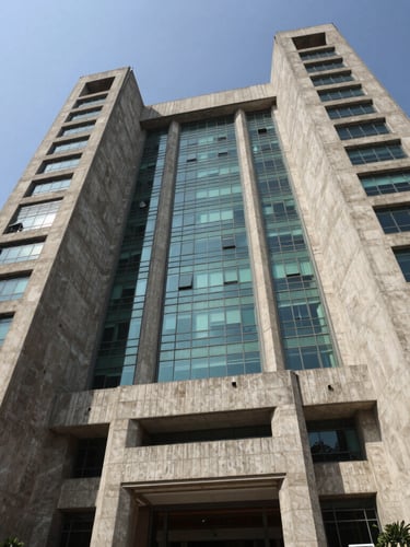 Low-angle architectural photograph of a massive concrete and glass civic headquarters in New Delhi, crisp structural geometry, deep shadows, bright daylight.