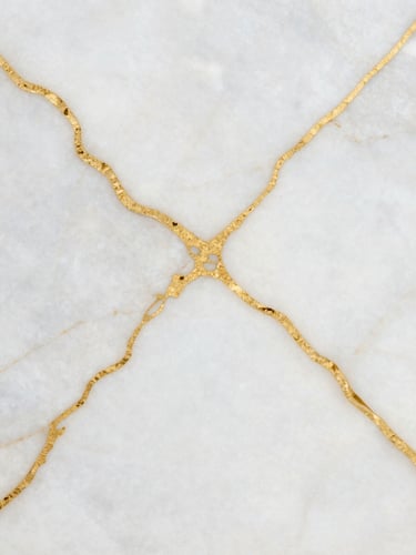Extreme close-up of polished white alabaster marble with natural gold veins, soft shadows, luxury architectural texture