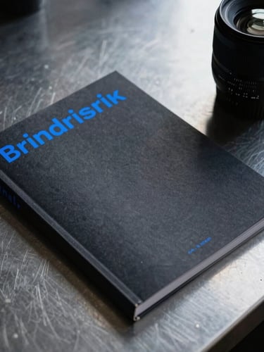 Close-up of physical brand guidelines book on a heavy steel table, sharp high-contrast studio lighting, deep charcoal shadows, electric blue accents, 35mm lens.