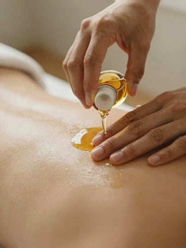 Close-up of hands gently pouring warm herbal oil onto a client's back, soft diffused golden-hour light, earthy muted tones, shallow depth of field, 35mm film