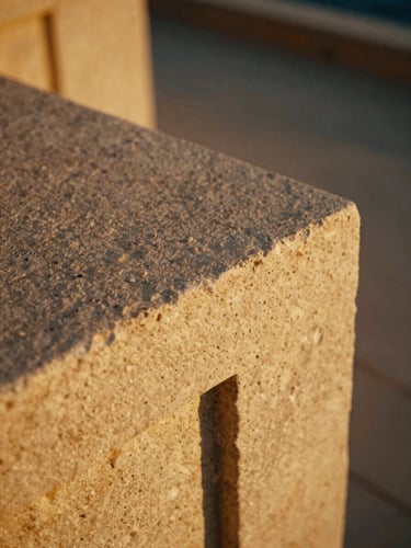 Cinematic close-up of tactile luxury linen and stone textures in golden hour light, shallow depth of field, 35mm film aesthetic