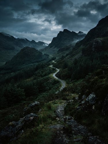 Moody outdoor photography of a rugged mountain pass at dawn, low-key early morning light, deep forest green tones, 35mm film grain