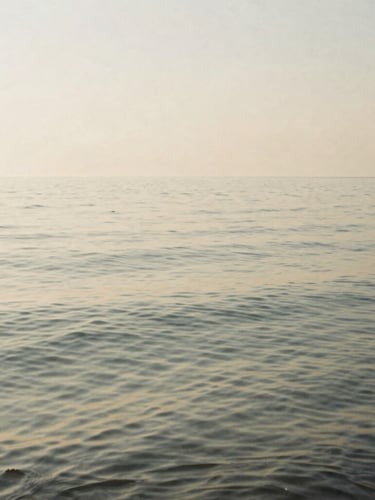 Wide-angle minimalist film photography of still water with gentle ripples at sunrise, soft diffused morning light, desaturated warm sand and sage tones, quiet contemplative mood.