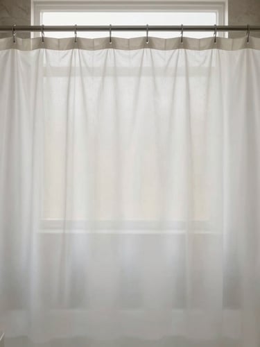 Straight-on eye-level shot of a minimalist bathroom, a water-repellent fabric shower curtain hanging on a sleek rod, soft morning light, muted stone tones
