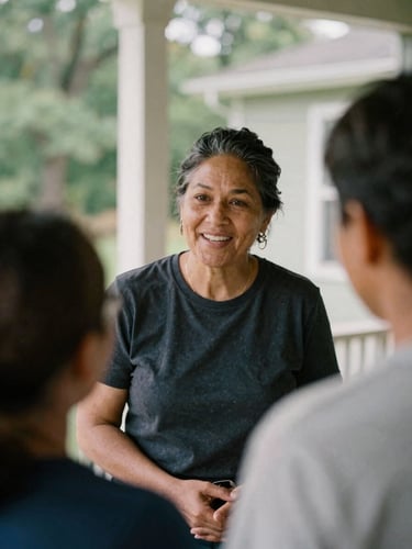 Candid close-up of a community organizer speaking warmly with a resident on a sunlit porch, soft natural daylight, deep muted forest tones, 35mm film style