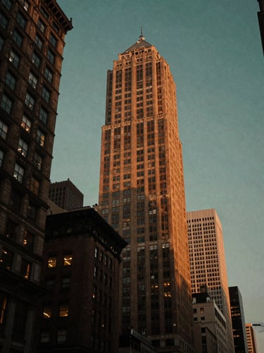 Moody editorial photography of West 57th Street at dusk, warm low-key ambient light, towering luxury buildings against a deep twilight sky, 35mm