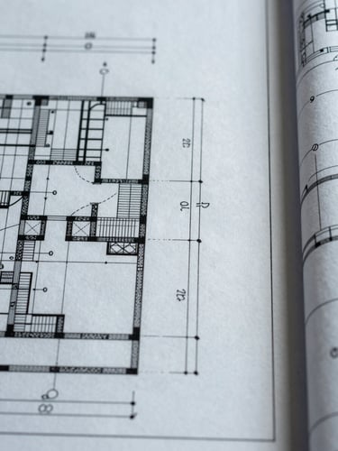 Extreme close-up of a technical blueprint sheet, precise linework and dimension annotations filling the frame, overhead flat lighting, fine pen traces and measurement callouts sharp against pale drafting paper, right edge kissing the frame boundary